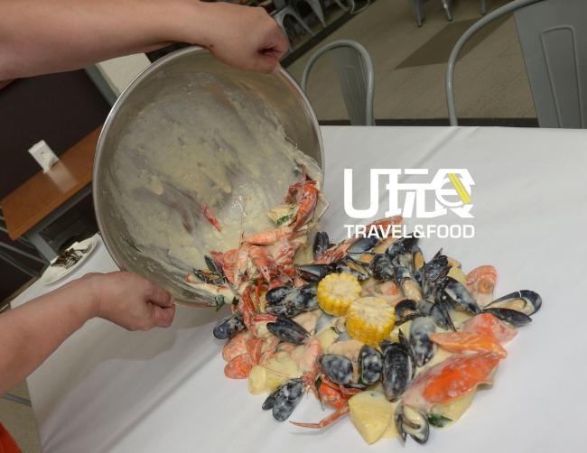 把海鲜全倾撒在食桌上，以手替代餐具，是目前食界新潮流。