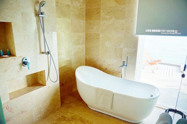 浴室里有淋浴设备 (Rain Shower)、浴缸 (Bathtub)和海景落地玻璃