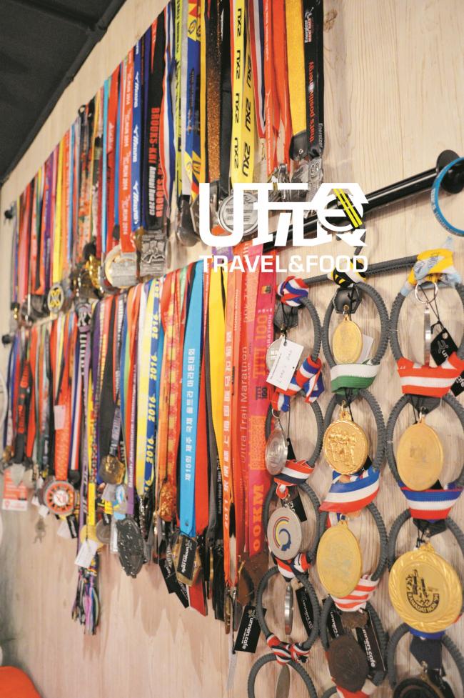 店内的墙上挂满了店主及友人多年来在国内外参加马拉松竞赛的吊牌和奖牌。墙上的小区块还贴了慢跑和马拉松资讯。