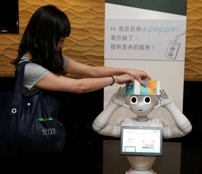 长荣航空公司在桃园机场及松山机场设置的人形机器人Pepper，服务全面升级，具备全球首创扫描登机证导览功能（如图），也增加英语、日语服务，让旅客轻松掌握各项资讯。