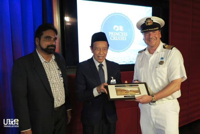 图为槟城港口有限公司邮轮码头事务部主任陪同赛艾迪赠送纪念品给克瑞斯立。