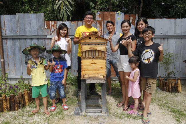 山城蜂蜜园负责人之一的邓灿良（次排左2）都会向前来的参观者讲解有关养蜂的知识。