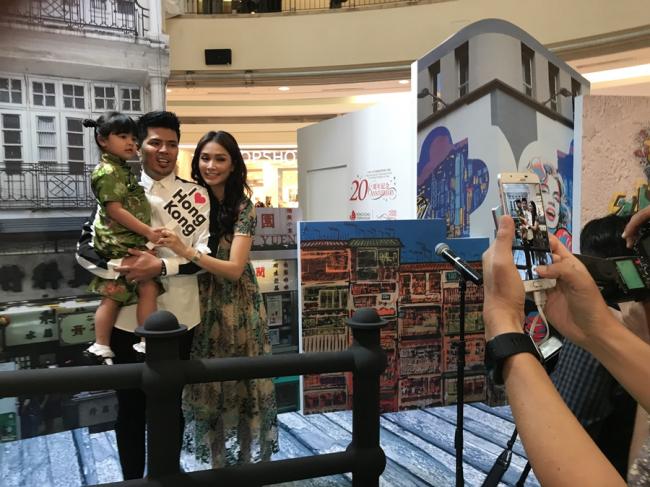 Awal Ashaari、Scha Alyahya与3岁女儿Lara Alana于香港旅游博览会上的景点展板合影。