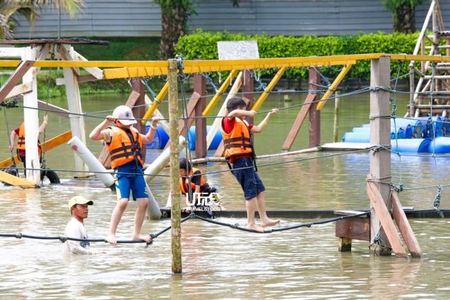 孩子们享受水上活动带来的乐趣，现场有工作人员监督。
