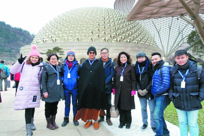 继程法师（左4）与周金亮（左5）一行人参访南京牛首山佛顶寺，适逢大雪纷飞，天寒地冻，众人在外合照。右4为梵声音会总监拿汀陈瑞莱。
