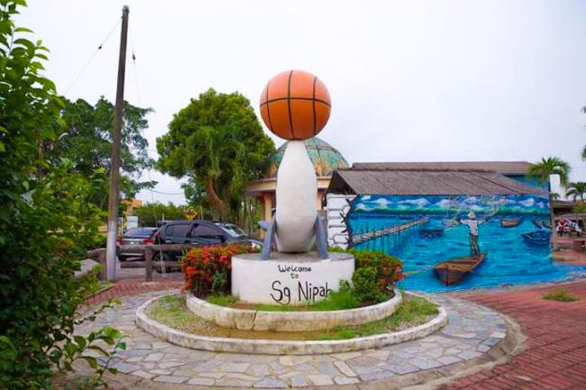 除了游乐场，村里还有一个休闲园区，背景为造景瀑布，前方则是壁画以及代表村子的「吉祥物」——海豚顶篮球！