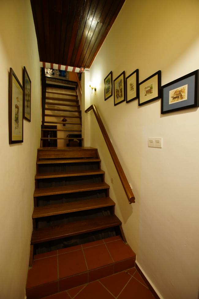 楼梯两旁展示本地画家所绘的老屋及街景作品，让住客欣赏及购买。