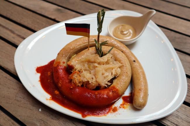 <b>Grilled Neuberger Sausage</b> 卷曲鸡肉香肠配上传统咖喱酱、芥末酱、酸菜和厨师特制的土豆泥，搭一杯啤酒，感受德国人庆祝啤酒节欢乐的氛围。<i>售價：20令吉</i>