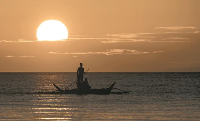 经过6个月修复，长滩岛已不再是菲律宾总统杜特蒂口中的「化粪池」。夕阳下，渔民乘着小船在海上捕鱼。 -法新社-