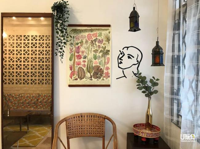 踏入客厅的一隅，古早味的藤椅、中东色彩式吊灯、外国购入的植物挂图，金瓶子上的植物，而墙壁上的人物图绘其画龙点睛之效，让原本静谧的角落鲜活起来。