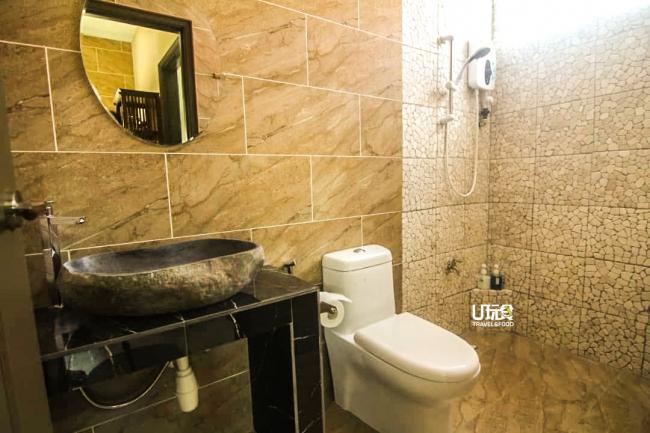 厕所采用带有巴厘岛风格的原石面盆，让人误以为身处在巴厘岛中。