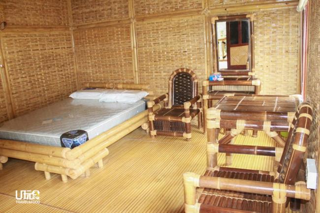 双层楼的竹屋客房宽敞舒适，除了一张双人床，还摆放了竹制的桌椅和梳妆台。