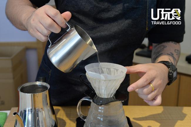 把热水倒入滤杯，让水润湿滤纸，去除滤纸的味道，并将滤杯和咖啡杯一并淋湿加温。