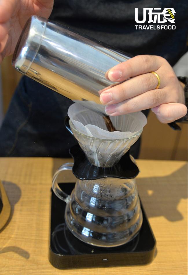 将磨好的咖啡粉倒入铺好滤纸的滤杯中。