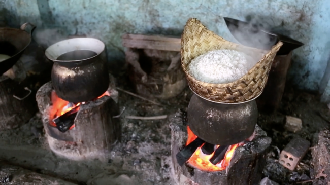 阿姨仍使用烧柴生火的方式烹煮制作糕点的材料。