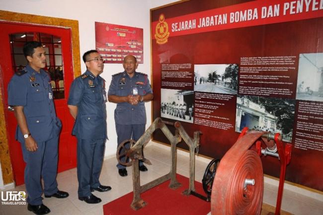 卡玛鲁扎曼（右）为卡玛鲁扎曼玛叻（中）介绍展示馆，以及眼前百年历史的消防水管卷盘。