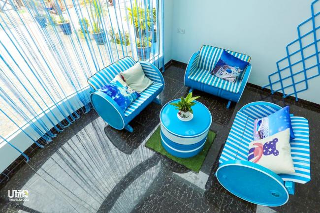 民宿客厅拥有落地玻璃窗，沙发以地中海蓝白色调为主，打造地中海风情主题。