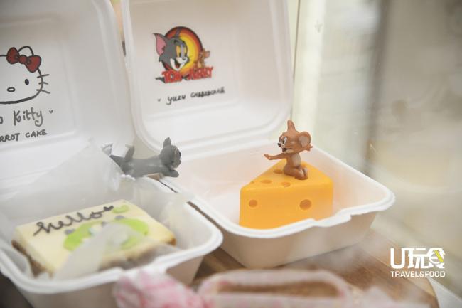 <b>Carrot Slice Cake</b>（左）与<b>Yuzu Cheesecake</b>上都有可爱逗趣的模型作为摆饰。为了让其更具特色，店家採用了再循环纸盒做为小蛋糕的「盘子」呈上。