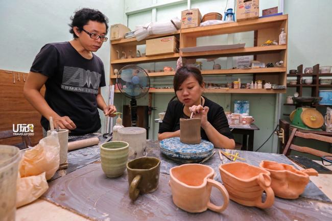 李志良（左）在陶土工作坊中指导学生进行手作陶土作品。