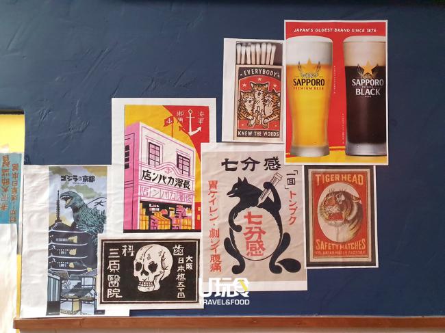 墙上贴着的海报都带有日式文化、建筑与老虎标志图案的海报，日味十足。
