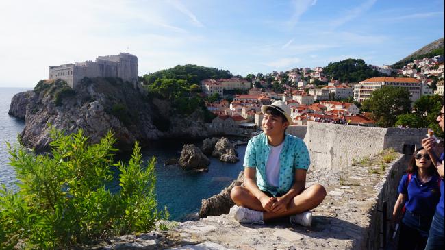 一个人与克罗地亚的漂亮景色合照。