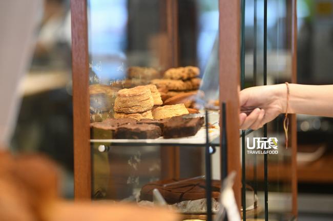 柜台上的橱窗里也陈列著售卖的自制曲奇饼、烤饼（Scone）咖喱泡芙及招牌布朗尼蛋糕等。