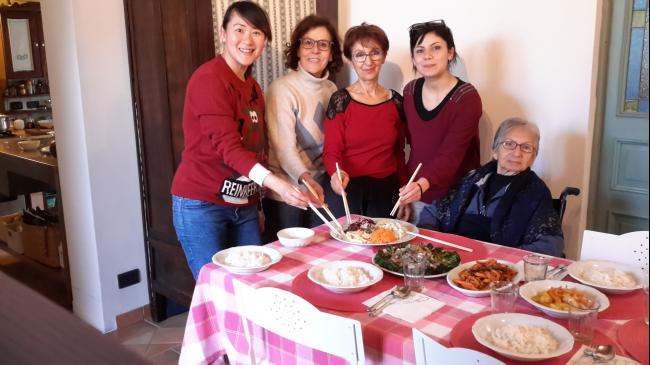2017年的大年初一，梁韵矜在意大利西西里与宿主弗朗西斯卡（中）的一 家一起穿上红色衣裳，握起了筷子，围在她巧制的素食捞生周围，用各自熟悉的语言说了很多寓意吉祥的话，就像在熟悉的家中过年一样。