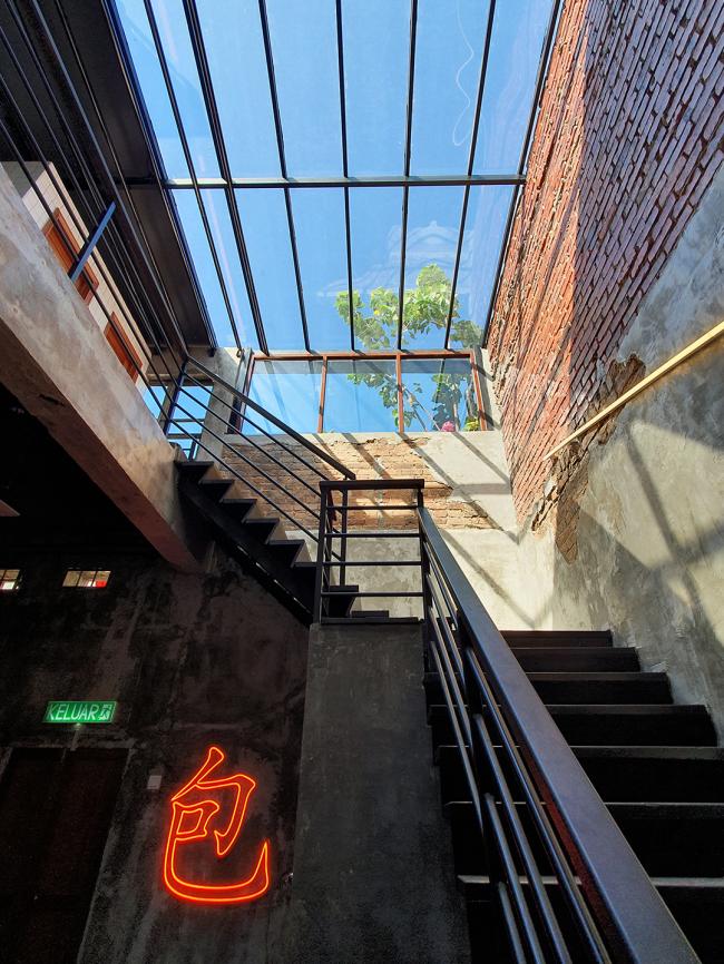 通往二层酒吧的阶梯上为透明的天窗设计，而阶梯旁的墙上也设有「包」字的霓虹灯，非常适合访客们在此打卡。