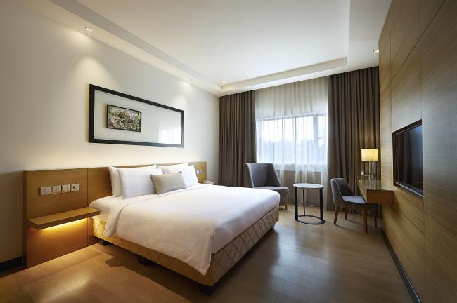 图为安莎酒店的Ansa Deluxe King房型，客房采用素色和木质元素，乍看之下整洁明亮。