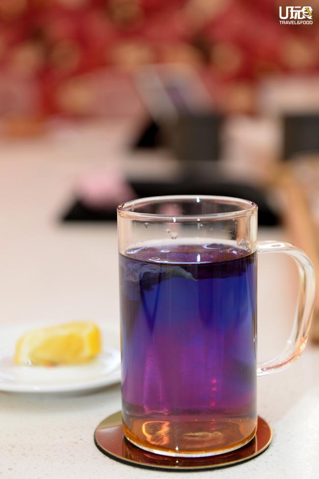 图为蝶豆花所散发的温柔蓝色饮料，挤上几滴柠檬汁，可见渐变效果，口感清甜带酸，是店内的特制饮品之一。