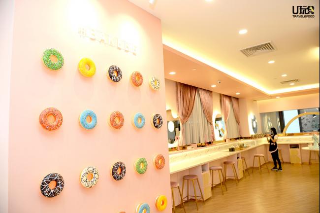 Bakebe体验店整体空间宽敞明亮，装潢以粉色为主，充满少女感；店内也备有多处饰以可爱甜甜圈元素的打卡热点，为顾客提供良好的烘焙体验。