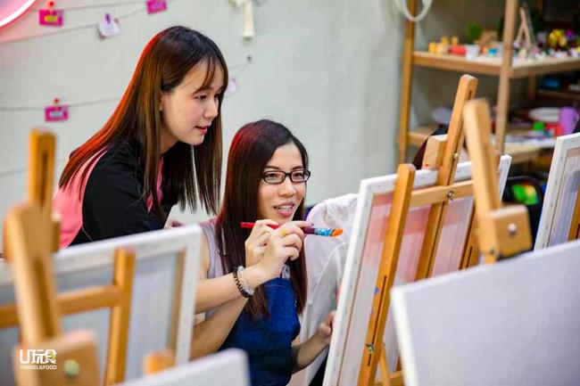 每次活动，詹维湘（左）都会在现场为每位需要帮助的学生提供适当的帮助，引导他们完成自己的作品。