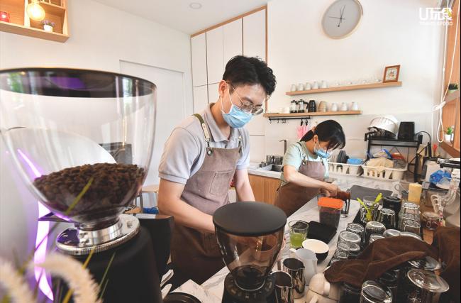 郭家辉与陈慧雯两夫妇各司其职，分别负责饮料冲泡和糕点烘制的工作。