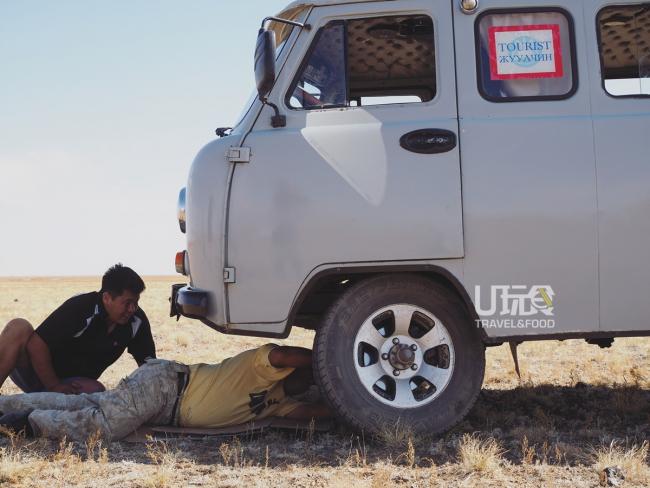 戈壁沙漠几乎没有泊油路，奔驰在干草原上的小货车由于过于颠簸，整个车轮都被震歪了，司机只能在空无一人的沙漠上修起车来。